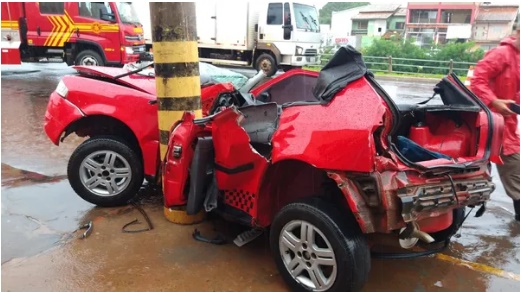 Vídeo: Carro aquaplana, motorista bate em poste e é resgatado pelo teto